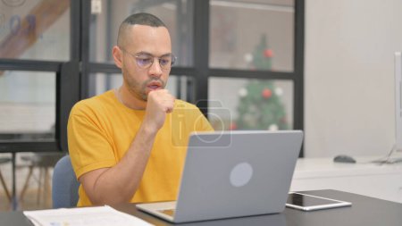 Foto de Toser hombre de raza mixta utilizando el ordenador portátil - Imagen libre de derechos