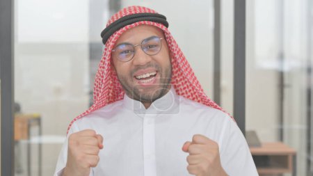 Téléchargez les photos : Portrait de jeune homme arabe célébrant le succès - en image libre de droit