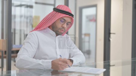 Téléchargez les photos : Jeune Arabe travaillant sur des documents d'affaires - en image libre de droit