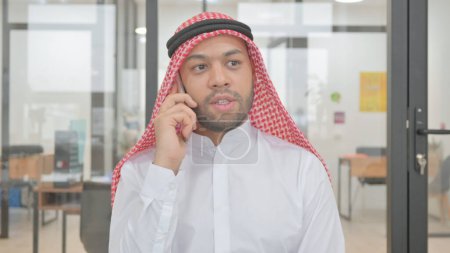 Téléchargez les photos : Portrait d'un jeune musulman parlant au téléphone - en image libre de droit
