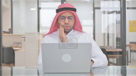 Téléchargez les photos : Jeune homme musulman avec mal de dents au travail - en image libre de droit