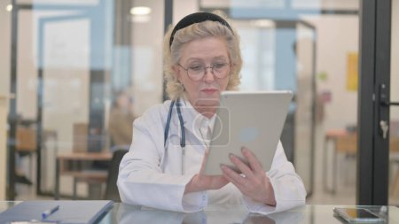 Téléchargez les photos : Médecin Féminin Senior utilisant la tablette en clinique - en image libre de droit
