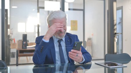Téléchargez les photos : Homme d'affaires sénior choqué par la perte au téléphone au bureau - en image libre de droit