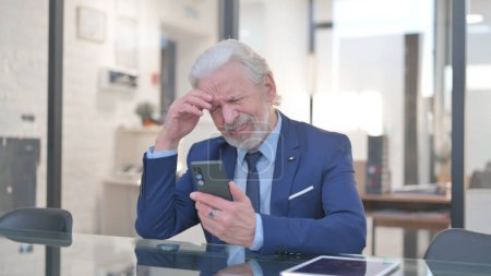 Photo for Old Businessman Shocked by Loss on Phone in Office - Royalty Free Image