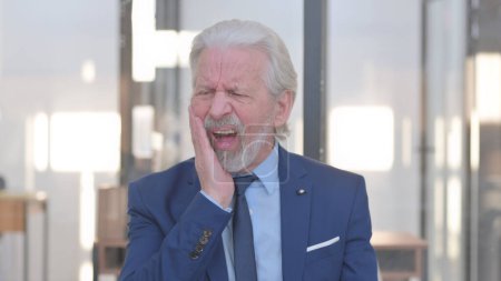 Téléchargez les photos : Homme d'affaires âgé inconfortable avec mal de dents au bureau - en image libre de droit
