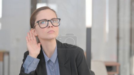 Téléchargez les photos : Portrait de jeune femme d'affaires essayant d'écouter des informations secrètes - en image libre de droit