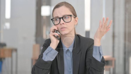 Téléchargez les photos : Portrait d'une jeune femme d'affaires en colère faisant parler le téléphone - en image libre de droit