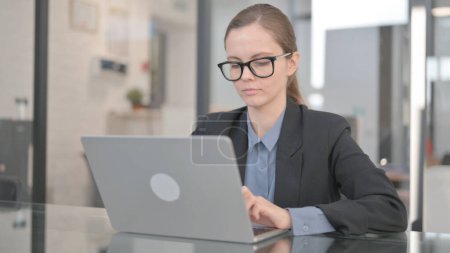 Téléchargez les photos : Femme d'affaires tapant sur ordinateur portable dans le bureau - en image libre de droit