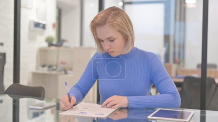 Junge Frau erledigt Büroarbeit im Büro