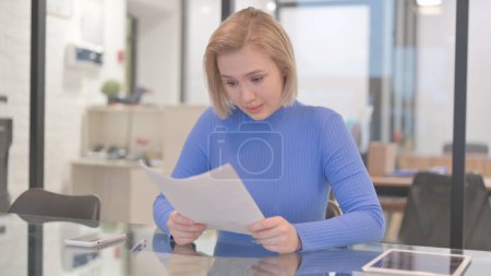 Téléchargez les photos : Jeune femme se sentant bouleversé tout en lisant Contrat - en image libre de droit