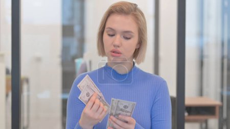 Porträt einer jungen Frau beim Geldzählen
