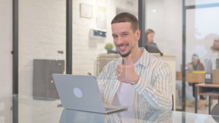 Photo for Creative Young Man with Thumbs Up while Working in Office - Royalty Free Image