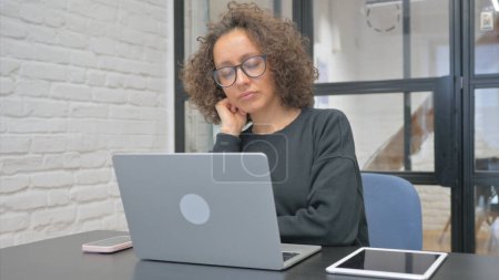 Photo for Tired Hispanic Woman Sleeping while Sitting in front of Laptop - Royalty Free Image