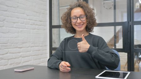 Photo for Hispanic Woman Showing Thumbs Up at Work - Royalty Free Image
