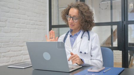 Photo for Hispanic Female Doctor Talking with Patient Video Conference - Royalty Free Image
