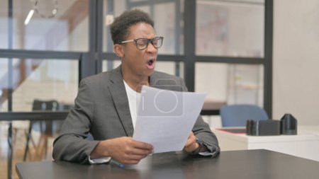 Photo for African American Man Feeling Upset while Reading Contract - Royalty Free Image