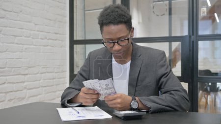 Jeune homme africain Compter de l'argent et faire de la paperasserie