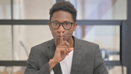 Téléchargez les photos : Portrait de l'homme afro-américain demandant le silence, doigt sur les lèvres - en image libre de droit