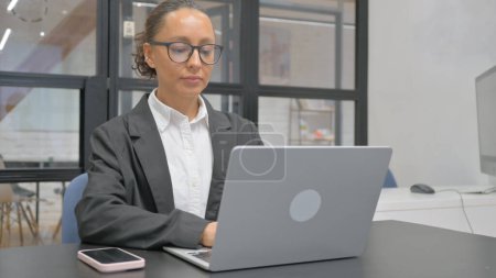 Téléchargez les photos : Hispanique femme d'affaires travaillant sur ordinateur portable au bureau - en image libre de droit