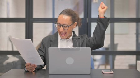 Téléchargez les photos : Une femme d'affaires métisse célèbre un nouveau contrat au pouvoir - en image libre de droit