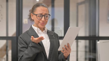 Photo for Portrait of Hispanic Business Woman Upset by Loss on Tablet - Royalty Free Image