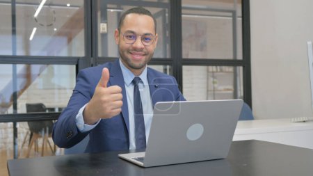 Photo for Thumbs Up by Man in Suit Using Laptop - Royalty Free Image