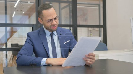 Photo for Man in Suit Feeling Upset while Reading Contract - Royalty Free Image