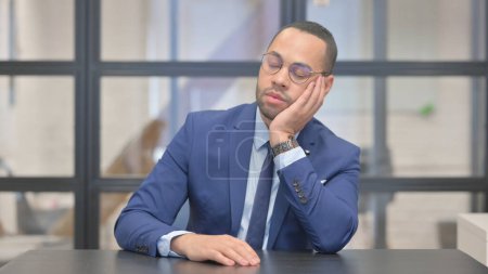 Téléchargez les photos : Homme d'affaires mixte endormi assis au bureau - en image libre de droit