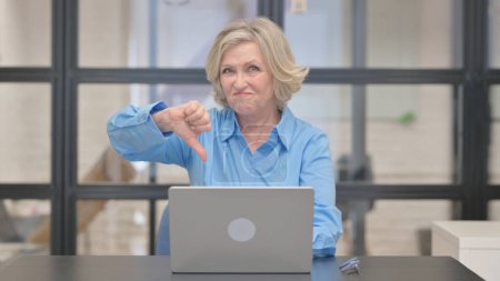 Téléchargez les photos : Pouces vers le bas par Old Businesswoman travaillant sur ordinateur portable - en image libre de droit