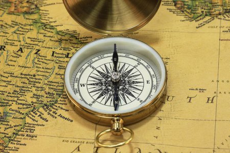 Photo for Classic round compass on background of old vintage map of world as symbol of tourism with compass, travel with compass and outdoor activities with compass - Royalty Free Image