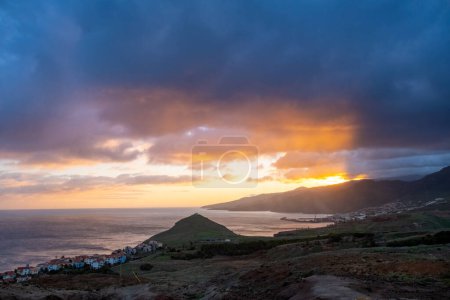Foto de Puesta de sol en la península de Ponta de Sao Lourenco con un pequeño pueblo tradicional. Isla de Madeira Portugal. - Imagen libre de derechos