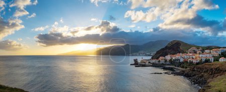 Foto de Puesta de sol en la península de Ponta de Sao Lourenco con pueblo tradicional. Isla de Madeira Portugal. - Imagen libre de derechos