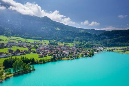 Foto de Aérea de la aldea suiza Lungern con casas tradicionales, antigua iglesia Alter Kirchturm a lo largo del encantador lago verde esmeralda Lungerersee, cantón de Obwalden Suiza - Imagen libre de derechos