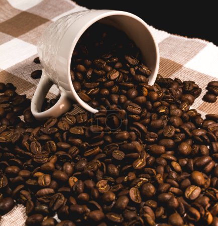 Photo for White cup overflowing with roasted coffee beans - Royalty Free Image