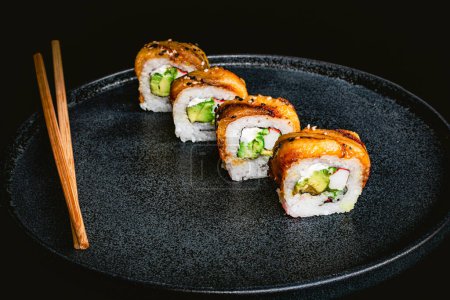 Foto de Rollos de sushi de plátano con cangrejo alineados en plato azul, fotografía de sushi delicioso y salsa de soja y palillos - Imagen libre de derechos