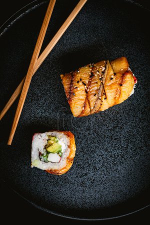 Foto de Rollo de sushi de plátano con cangrejo en plato azul, fotografía de sushi delicioso y salsa de soja - Imagen libre de derechos