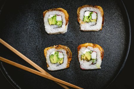 Foto de Cuatro rollos de sushi en plato azul, fotografía de sushi delicioso - Imagen libre de derechos