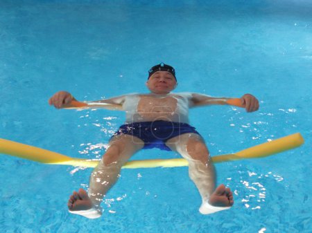 Photo for Smiling man lies on the water in the pool on swimming noodles close-up - Royalty Free Image