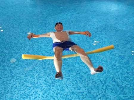 Photo for Smiling man lies on the water in the pool on swimming noodles. - Royalty Free Image
