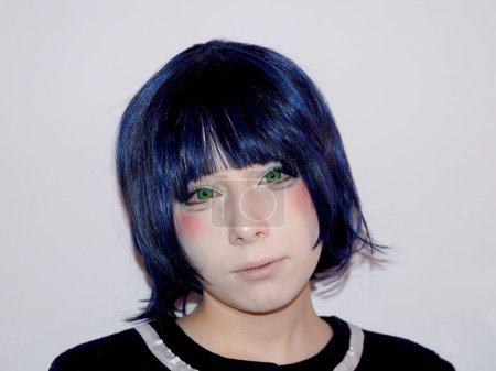Porträt eines traurigen Teenagers im Anime-Stil mit blauen Haaren und grünen Augen auf weißem Hintergrund