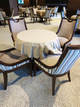 elegant dining chairs and round table in restaurant interior.
