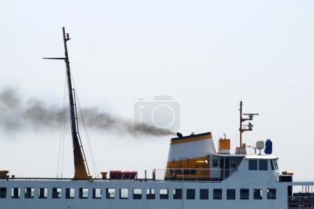 Téléchargez les photos : Fumée noire provenant de la cheminée d'un traversier à passagers près - en image libre de droit