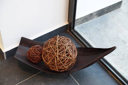 boules décoratives en osier dans un bol en bois décor à la maison.