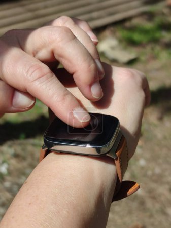 adjusting a smartwatch with a leather strap on the wrist.