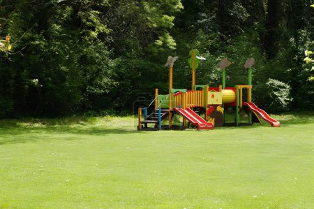 Kinderspielgeräte mit Rutschen im Park auf der Liegewiese.