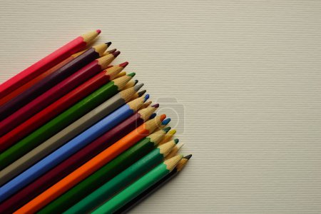 Téléchargez les photos : Un ensemble de crayons de couleur sur une table beige. - en image libre de droit