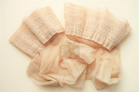 Foto de Beige stockings with lace elastic on silicone, close-up, top view on the table. - Imagen libre de derechos