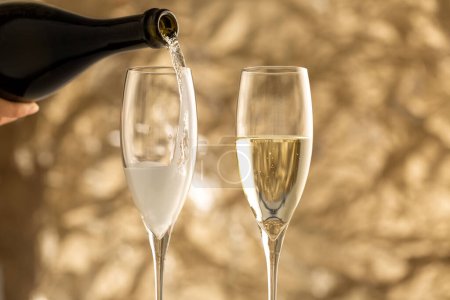 Photo for Festive photo of pouring sparkling wine into glasses - Royalty Free Image