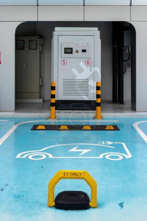 Foto de Estación de carga eléctrica, cargador público vacío en el estacionamiento de la ciudad decorado con color azul y blanco - Imagen libre de derechos