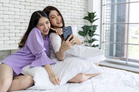 Photo for Memories before bedtime Young woman couple in bed Take a selfie with your phone Capture images through the lens of your smartphone. To create a collection of delightful shared moments. - Royalty Free Image